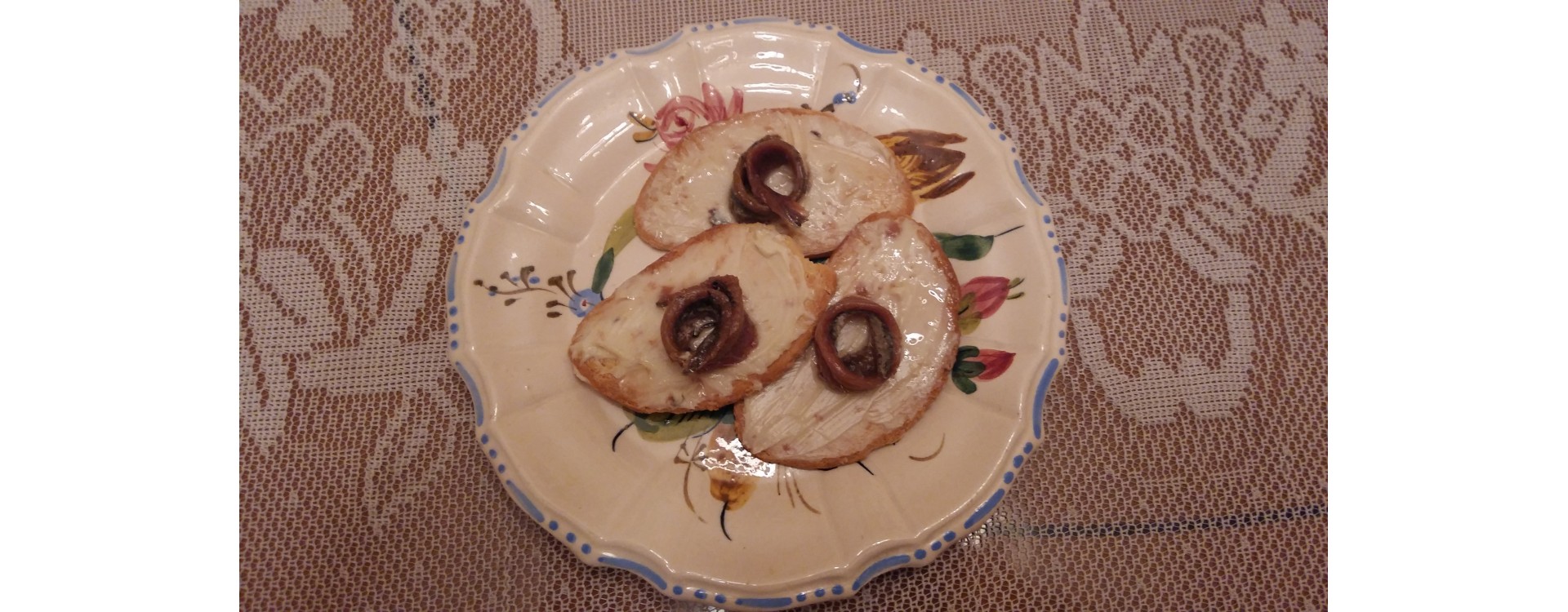 Slices of toasted bread with butter and anchovies in oil